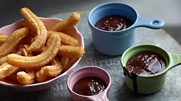 Churros — hiszpańskie pączki z sosem czekoladowym