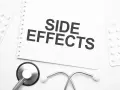 Notatka z napisem "SIDE EFFECTS" obok stetoskopu i opakowań leków. Czy NAC suplement ma skutki uboczne?