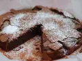 En saftig kladdkaka, pudrad med florsocker, redo att avnjutas. Perfekt för fikat eller som en del av ett dessertbord med andra kladdkaka kakor.