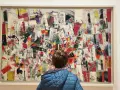 Un bambino ammira un quadro astratto dai colori vivaci, un'opera che evoca lo spirito audace di Peggy Guggenheim.
