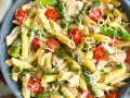 Penne z kurczakiem, szparagami i pomidorkami koktajlowymi, posypane parmezanem. Pyszne danie, które zachwyci każdego smakosza.