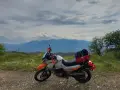 Motocykl gotowy na przygodę, z bagażami na wyprawę. Piękna grecja trasa z widokiem na góry.