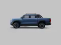 Niebieski pickup BYD Shark PHEV widziany z boku na szarym tle.