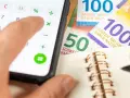 Rechnung für das Kostgeld der Kinder: Ein Handy mit Taschenrechner, Schweizer Franken und ein Notizbuch.