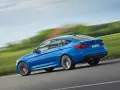 Niebieskie BMW 3 GT w ruchu, ukazujące jego sportowy profil. Warto rozważyć jego wady i zalety przed zakupem.