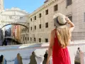 Una donna con un cappello di paglia ammira il Ponte dei Sospiri, un iconico ponte degli innamorati a Venezia, con i suoi canali e palazzi storici.