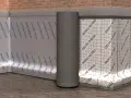 Eine Noppenbahn schützt die Wand vor Feuchtigkeit. Sie ist an der Ziegelwand befestigt, daneben eine weiße Bahn mit Gitternetz.