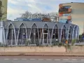 Charakterystyczna modernistyczna architektura budynku z przeszkloną fasadą i geometrycznymi elementami.