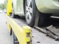 Czy komornik może zająć samochód osobie niepełnosprawnej? Auto na lawecie, zabezpieczone pasami.