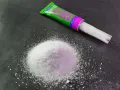 A pile of white granular material sits next to a tube of "Sekunden Kleber" super glue, ready for a quick fix.
