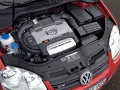 Silnik 1.4 TSI Twincharger w czerwonym Volkswagenie. Widoczne elementy układu dolotowego i chłodzenia.