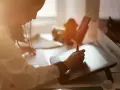 Kobieta tworzy grafikę komputerową, pracując przy tablecie graficznym i klawiaturze.
