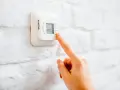 Ajustando el termostato para unos agradables grados calefaccion invierno.