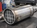 Metalowy filtr cząstek stałych GPF z widocznym wewnątrz wkładem o strukturze plastra miodu.