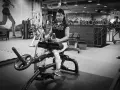 Kvinna tränar sittande vadpress på gym.
