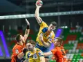 Gracz w żółtej koszulce rzuca piłkę do bramki, broniony przez zawodników w pomarańczowych strojach. Emocjonujący moment z meczu final four handball.