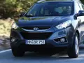 Dunkelgrauer Hyundai ix35 fährt auf einer Straße. Fahrer und Beifahrerin sind zu sehen. Mögliche Hyundai ix35 Probleme sind hier nicht ersichtlich.