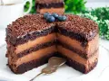 Pyszny tort czekoladowy z kremem i posypką, ozdobiony borówkami. Idealny na każdą okazję!