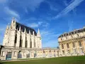 El castillo de Vincennes, con su imponente arquitectura gótica y clásica, se alza bajo un cielo azul vibrante.