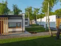 Nowoczesne domki na riviera camp otoczone zielenią i drzewami.
