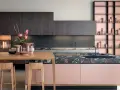Cucina moderna con isola rosa cipria e piano in pietra scura, pensili in legno scuro. Ottimi abbinamenti colori cucine moderne.