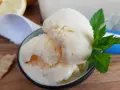 Erfrischendes zitronen joghurt eis mit Minze und einem Waffelstück auf Holztisch.