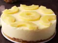 Tarta de piña cremosa, decorada con rodajas y trozos de piña fresca. ¡Un postre tropical irresistible!