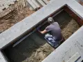 Budowlaniec wyrównuje świeży beton, pokazując, jak zrobić beton.