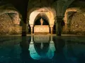 Sotterranei di Venezia misteriosa, con statue e riflessi sull'acqua.