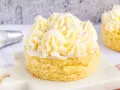 Kleiner Kuchen mit Buttercreme ohne Pudding, verziert mit lila Zuckerstreuseln.