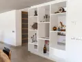 Libreria in cartongesso, perfetta come divisorio per l'ingresso, con oggetti decorativi e un cavallo a dondolo.