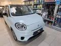 Jasnoniebieski Leapmotor T03 stoi w salonie samochodowym obok półek z akcesoriami.