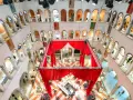 Interni del Fondaco dei Tedeschi con un'installazione di tende rosse al centro, che incornicia un'area bar e tavoli. Le arcate dei piani superiori ospitano negozi.
