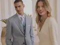Elegancki mężczyzna w jasnoszarym garniturze i kobieta w kremowej sukience. Idealne stylizacje, jak się ubrać na komunię.