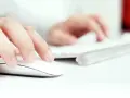 Dłoń klika myszką, przygotowując się do pobrania plików z darmowego serwera FTP.