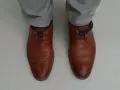 Scarpe marroni eleganti con lacci blu nascosti, un modo per allacciare le scarpe senza far vedere i lacci.