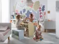 Dzieci bawią się w pokoju z pastelowymi kolorami, tworząc radosną atmosferę. Idealne kolory do pokoju dziecięcego.