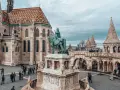 Budapeszt ceny: Rynek z pomnikiem konnym i Kościołem Macieja. Turyści zwiedzają zamek.