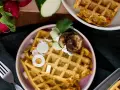 Herzhafte Waffeln mit Zucchini, Zwiebeln und gegrillten Auberginen, garniert mit Kräutern und einem Klecks Joghurt.