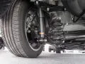 Widok od spodu samochodu z kołem, amortyzatorem i sprężyną. To auto ma rwd napęd, co zapewnia świetne wrażenia z jazdy.