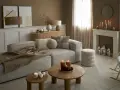Przytulny salon w odcieniach sepia kolor. Miękki narożnik, drewniane stoliki, kominek z świecami i ciepły pled tworzą atmosferę relaksu.