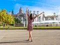 Kobieta cieszy się piękną pogodą w Barcelonie, z fontannami i pałacem w tle.
