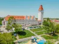Władysławowo: okazały budynek z wieżą, dawny dom rybaka, otoczony zielenią i placem zabaw.