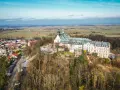 Widok z lotu ptaka na klasztor na świętej górze, otoczony lasem i miasteczkiem.