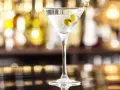 Klasyczny martini dry przepis: schłodzony gin, odrobina wermutu i dwie oliwki. Idealny drink na wieczór.