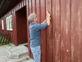 Man slipar fasaden innan målning.