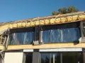 Budowa domu w toku: widoczne drewniane elementy konstrukcji, pianka montażowa i folia świadczą o postępach w pracach nad termoizolacją budynku.