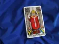Karta Tarota "The Hierophant" na niebieskim tle. Symbolizuje tradycję, duchowość i przewodnictwo.