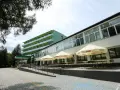 Tanie sanatorium prywatnie: zielony budynek z balkonami i tarasem z parasolami Tyskie.
