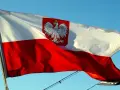 Polska bandera z orłem na tle błękitnego nieba. To symbol dumy narodowej, który powiewa na wietrze.